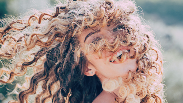 Girl smiling with curly hair.