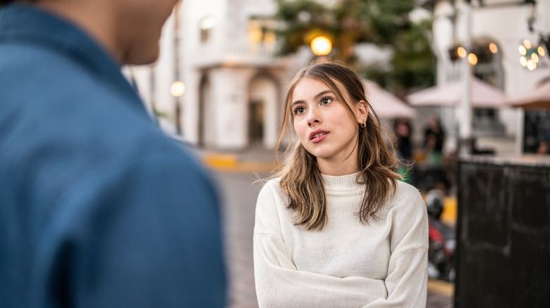 woman speaking to man outdoors