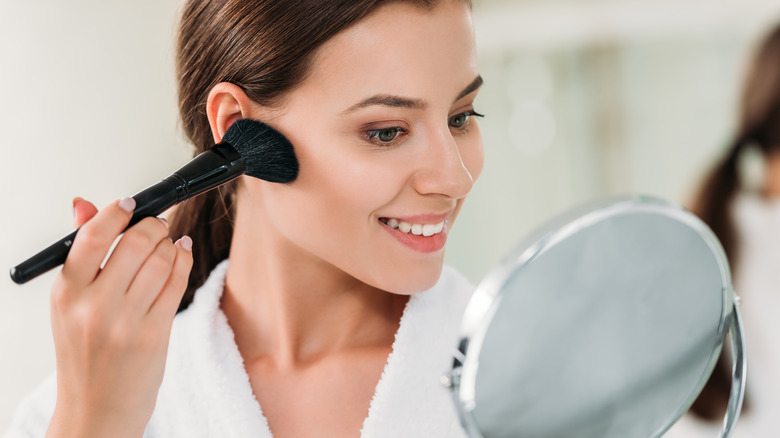 woman applying bronzer