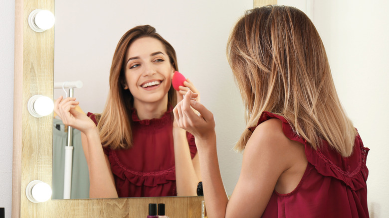 woman applying foundation with sponge