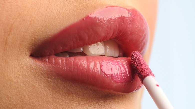 close up of woman applying lipstick 