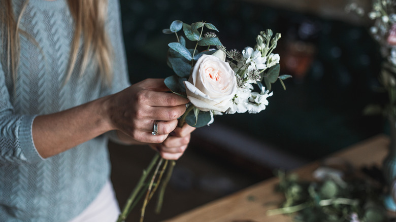 woman creating floral arrangement  