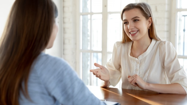 Smiling woman talking to woman