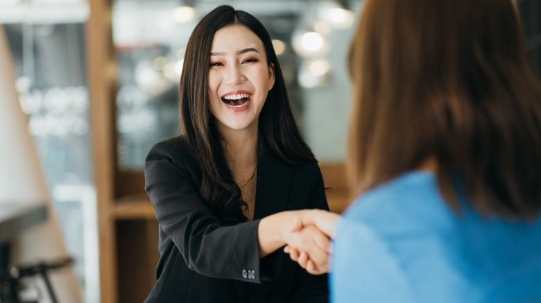 Women shaking hands and smiling