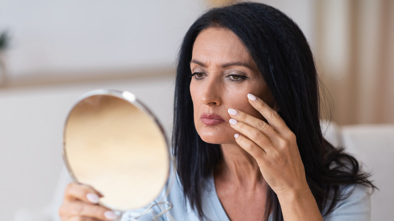 Woman unhappy looking in mirror