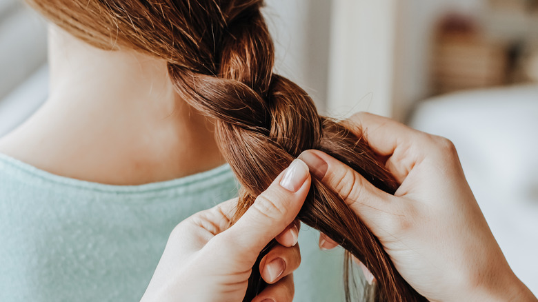 A woman braiding hair