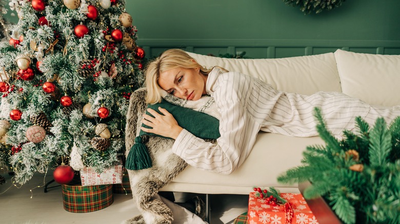 Sad woman laying on the couch during the holidays