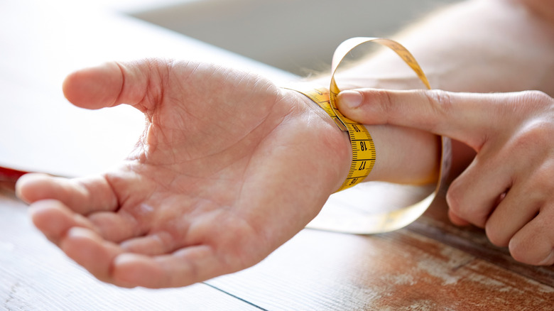 Model measuring wrist circumference