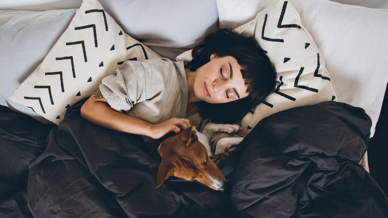 woman with puppy in bed