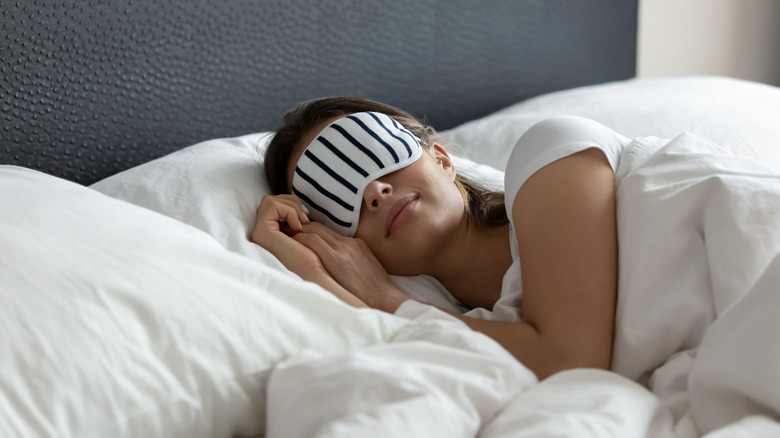 Woman resting in bed with an eye cover on