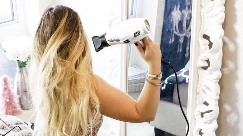 Woman blow drying her hair