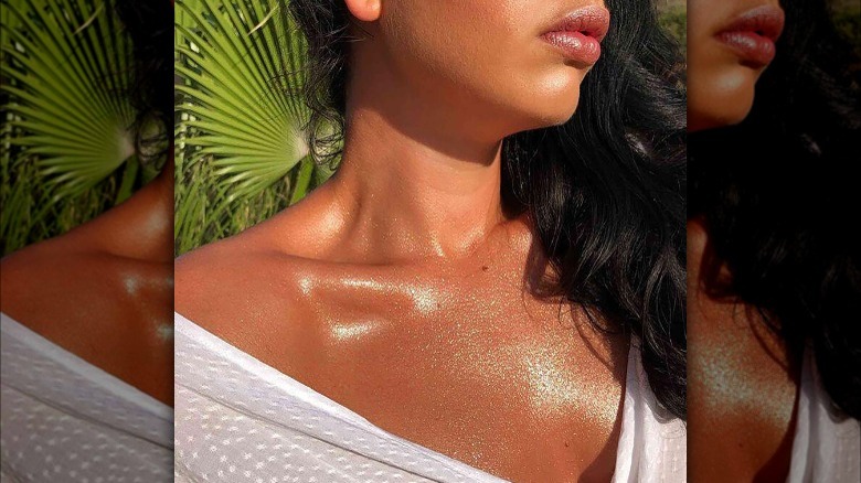 Shimmery body oil on tanned skin