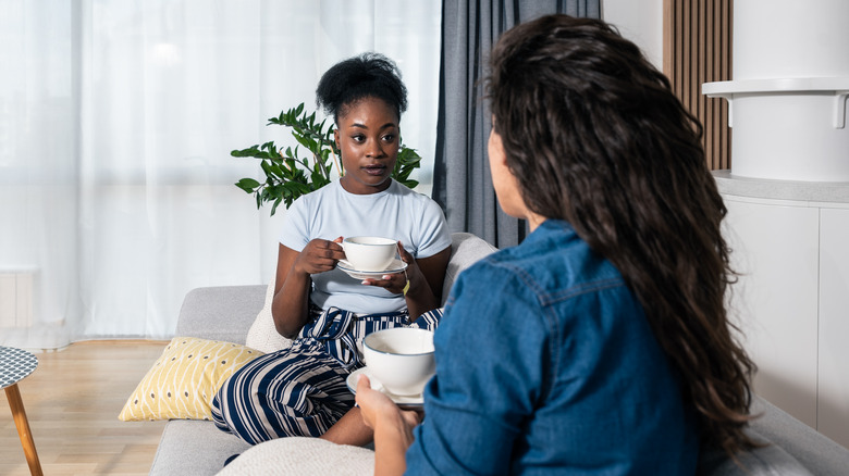 two women talking on sofa