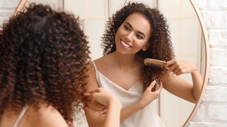 Woman combing curly hair