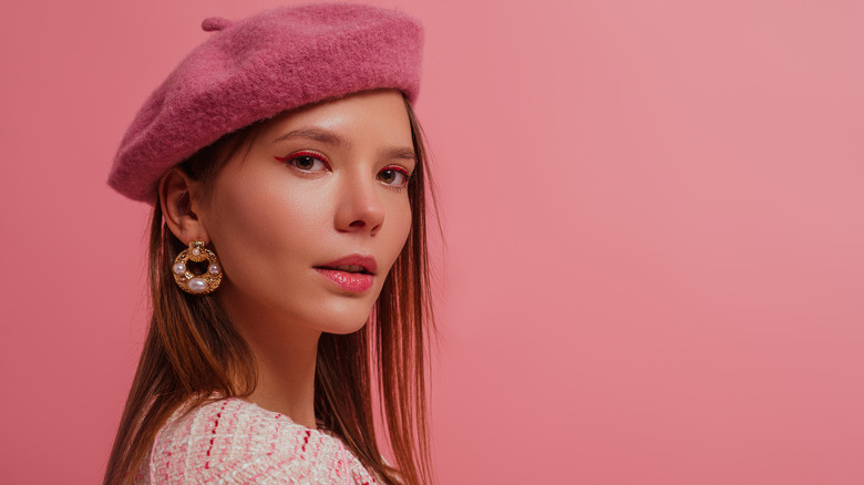 Model wears statement earrings and beret