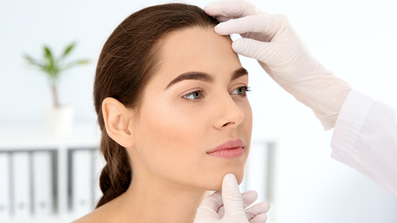 Model being examined by gloved hands