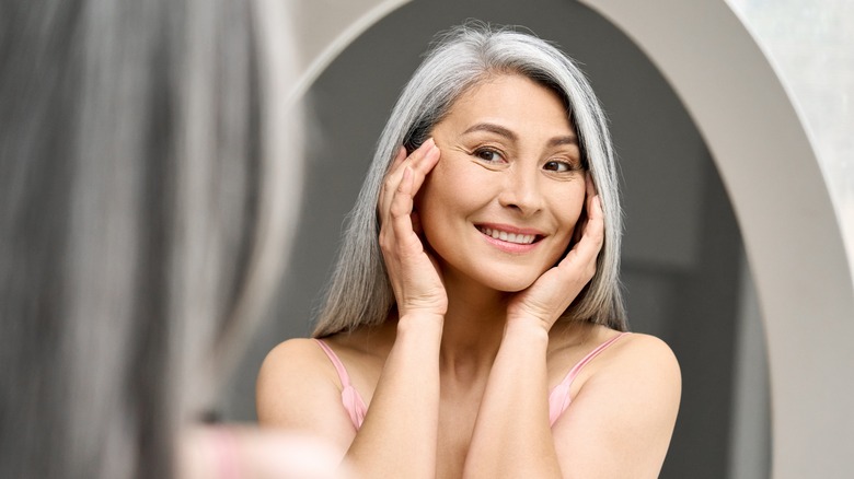 Woman looking in mirror, smiling