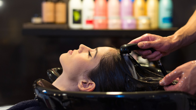 A woman getting her dark hair washed