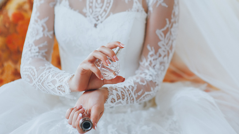 Bride applying perfume spray to wrist