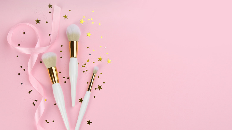 makeup brushes on pink background