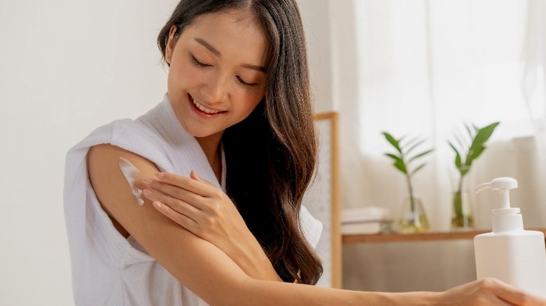 Woman applying lotion to skin