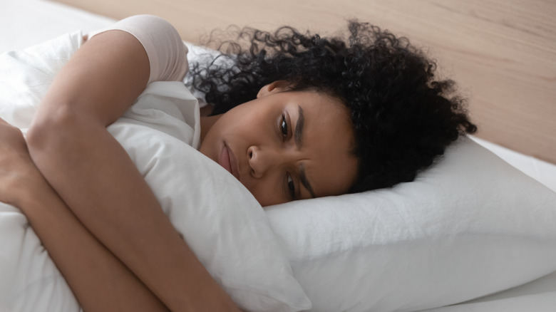 woman in bed hugging pillow