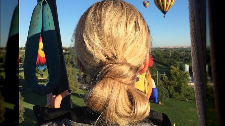 Woman with looped bun looking at hot air balloons