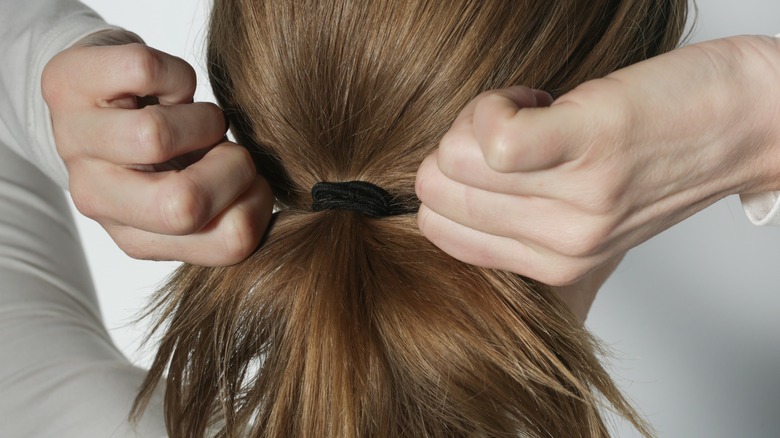 Woman putting hair in a ponytail