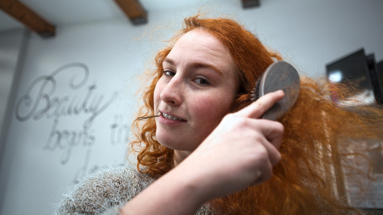 Redhead brushing hair