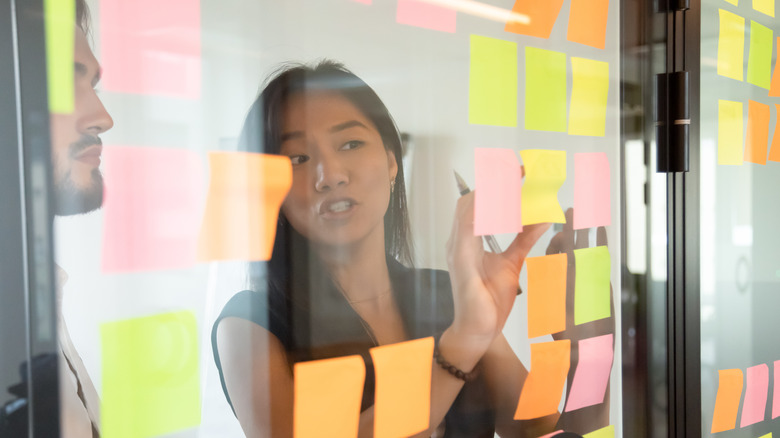 A woman scheduling posts with sticky notes