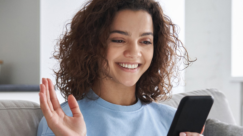 woman smiling looking at her phone