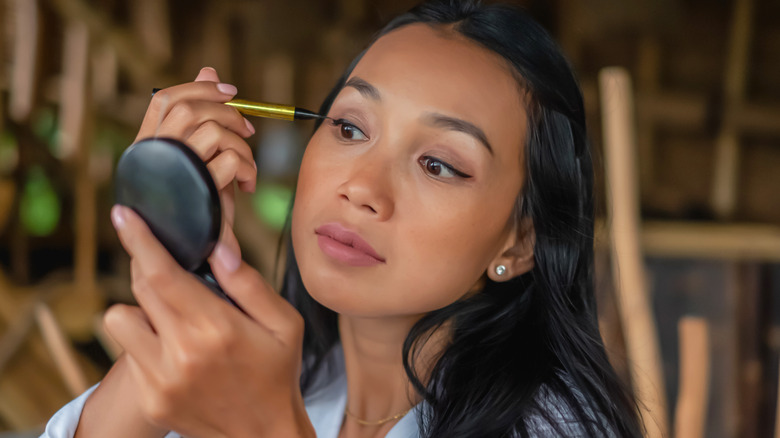 woman applying liquid eyeliner