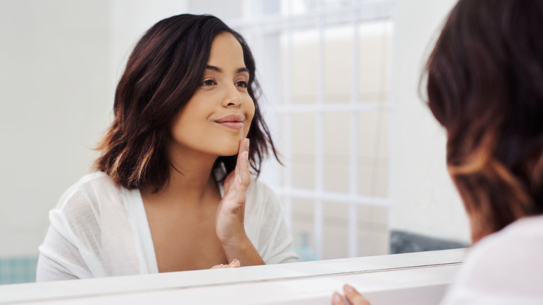 woman applying makeup primer