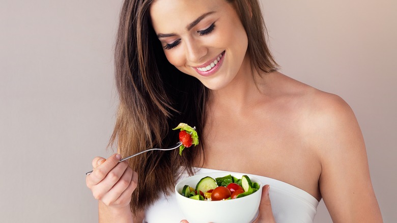 female eating a bowl of fruits