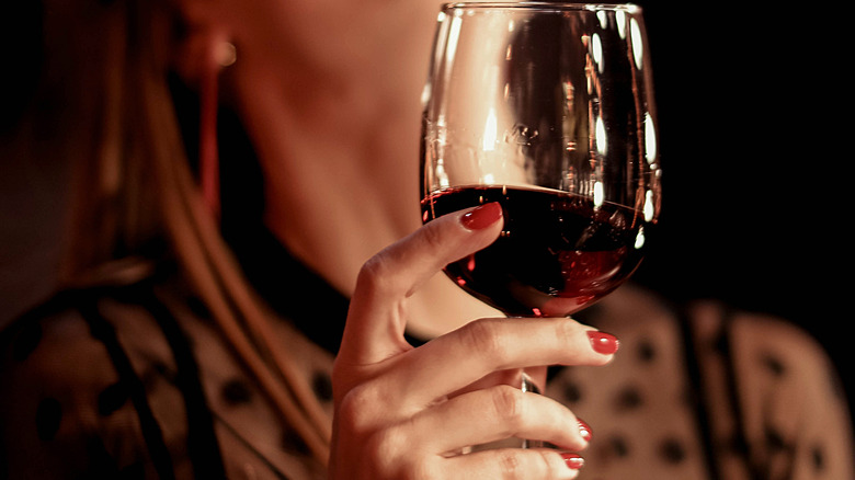 female holding a glass of red wine