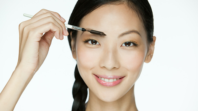 Woman brushing her eyebrows