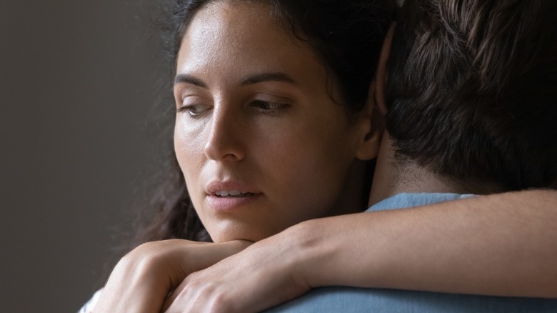 Woman hugging and looking away