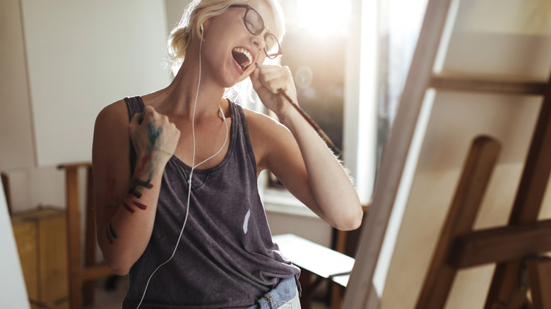 Bold woman sings into paint brush