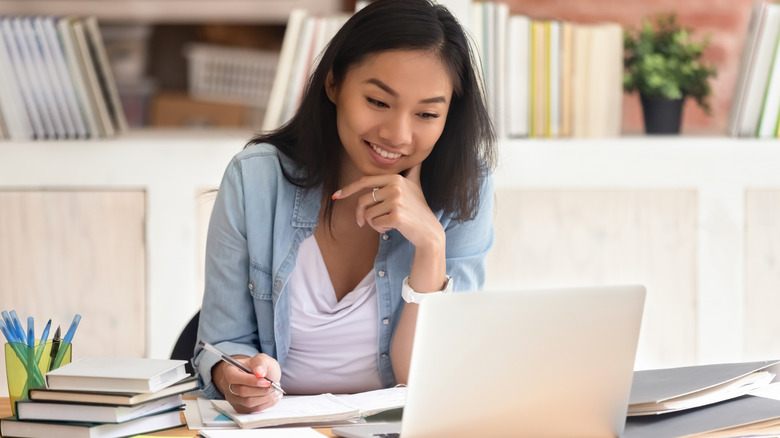 Woman takes notes from laptop