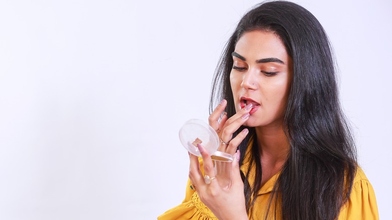 Woman dabbing lips with finger