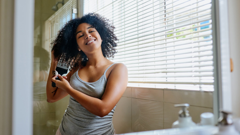 woman detangling hair with afro pick