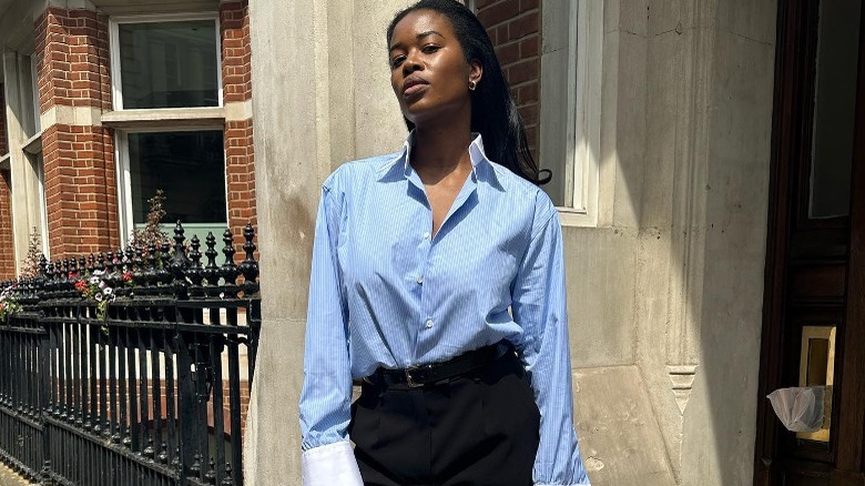 Person in blue blouse and black skirt