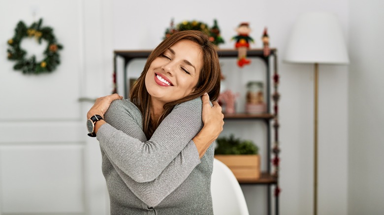 Woman hugging herself during holidays