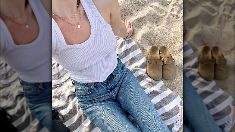 Woman wearing white tank, jeans