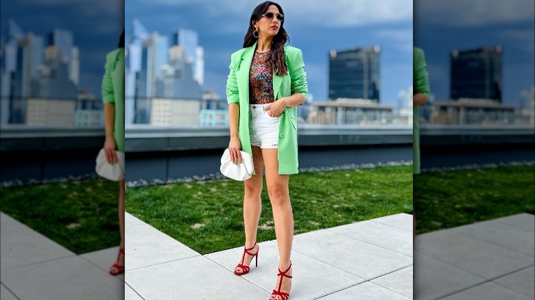 Woman in green blazer and white denim shorts.