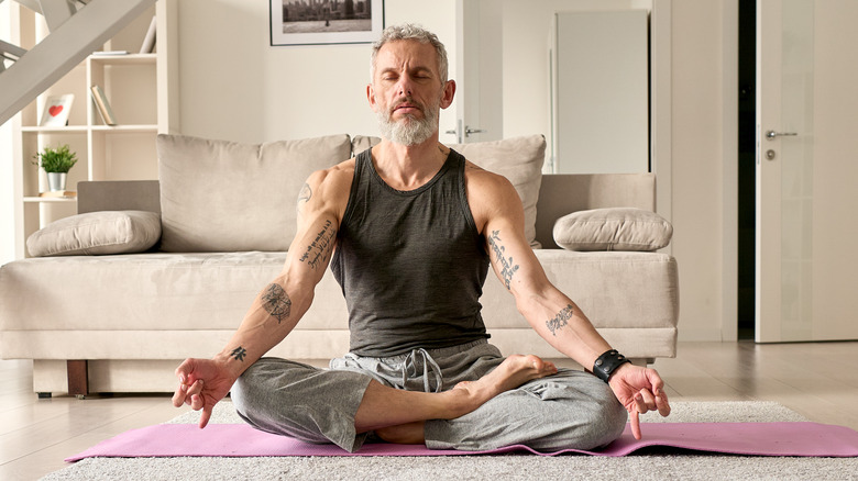middle-aged tattooed man meditating