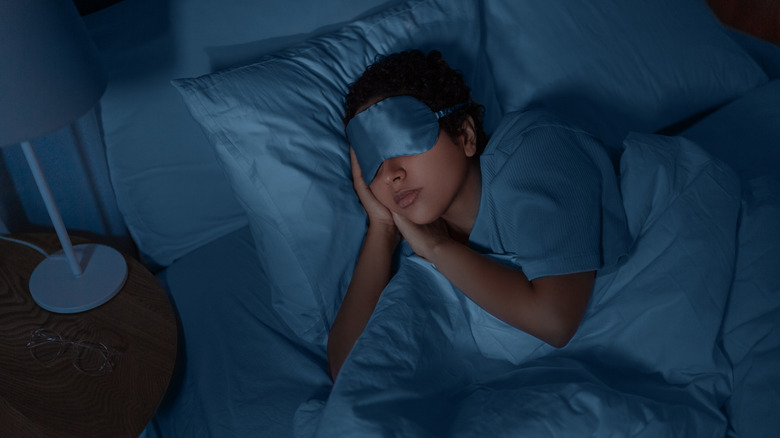 Person sleeping in bed with face mask