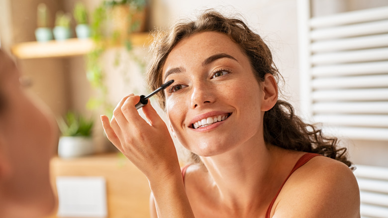 Woman applying mascara