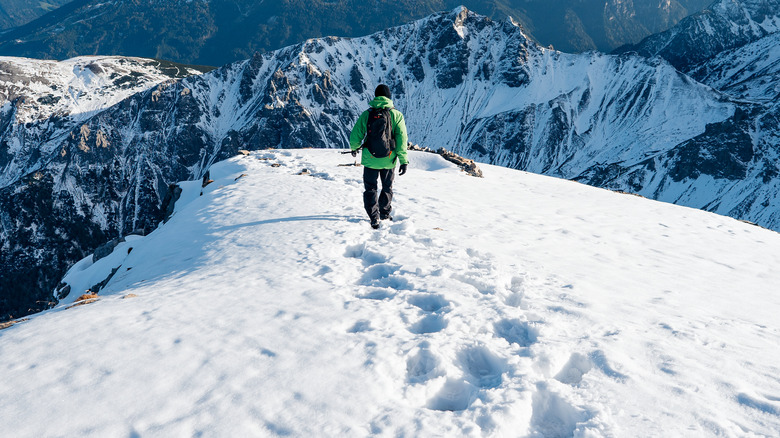 person hiking on snow-capped mountain
