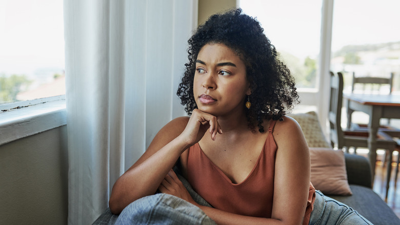 thoughtful woman looking out window